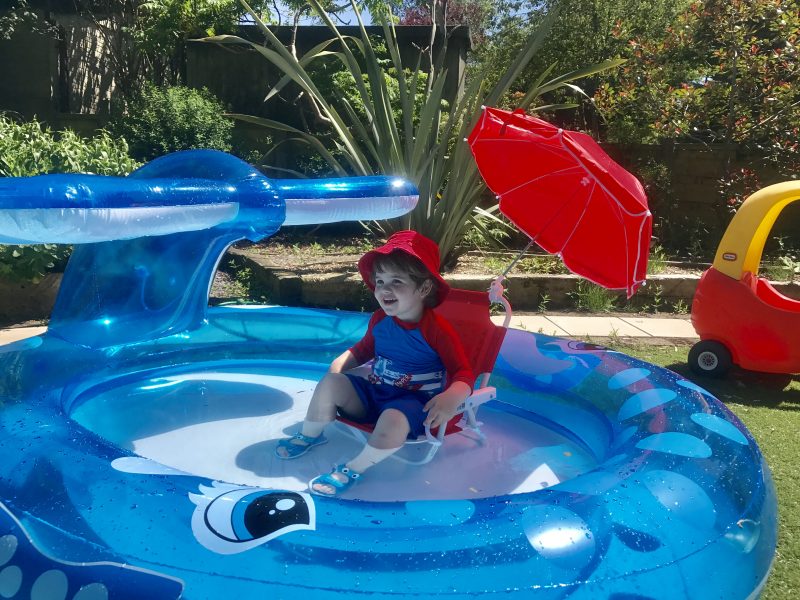 Toddler sitting on chair in paddling pool